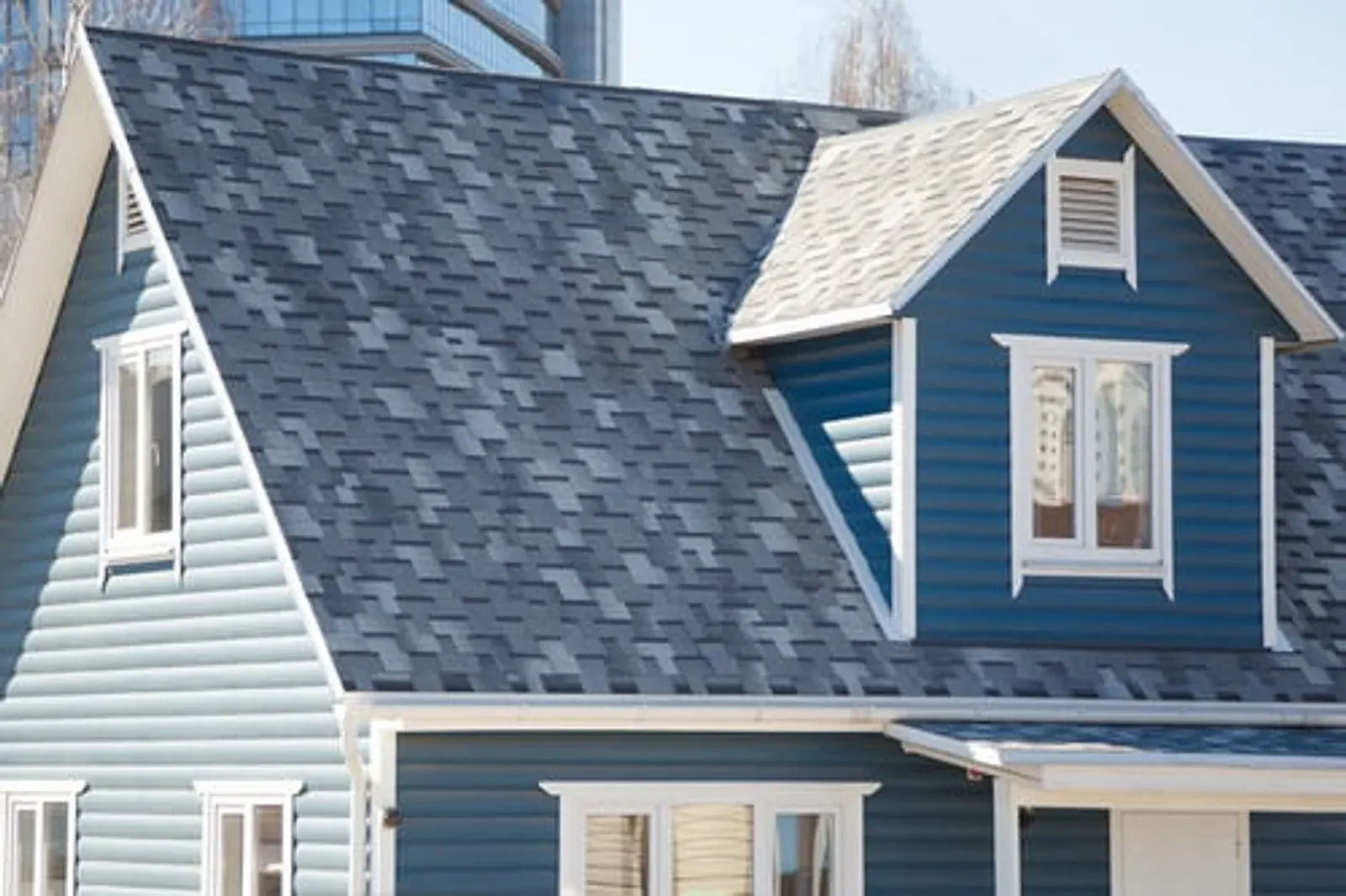 Two-storey home with light blue lap siding, white trim and a shingled roof