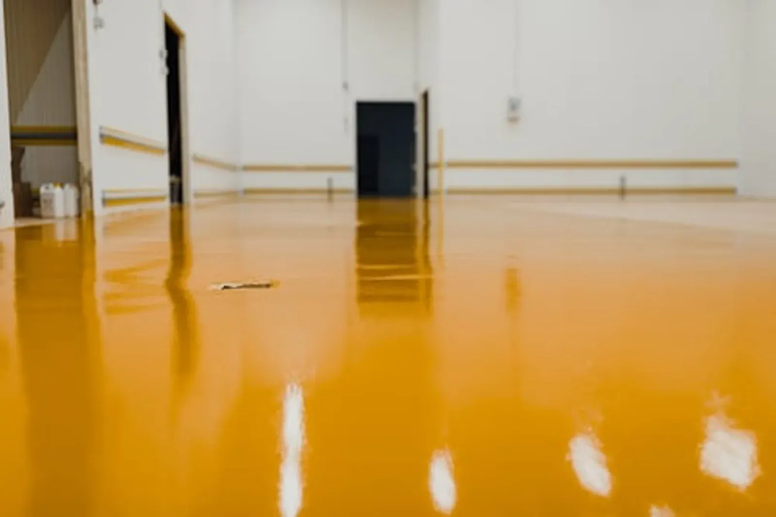 Glossy yellow epoxy resin floor coating in a bright commercial interior
